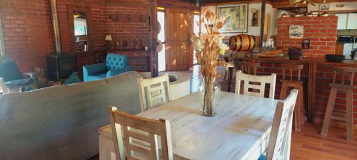 una mesa de madera con sillas y un jarrón. en Casona en Quillón, en Chillancito