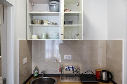 a kitchen counter with a sink and white cabinets at Sienna Apartments Budva in Budva