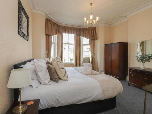 Un dormitorio con una gran cama blanca y una ventana. en The Causeway, en Llandudno
