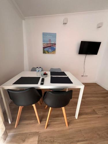 a white table and chairs in a room at Estrela da Almada Mascarenhas in Almada