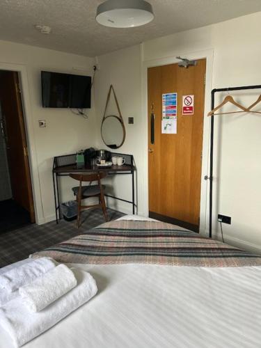 a bedroom with a bed with two towels on it at Cardross Inn in Cardross