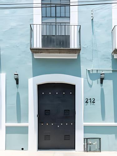 a building with a black door and a balcony at Casa 212 con WIFI alta velocidad y estacionamiento in Puebla