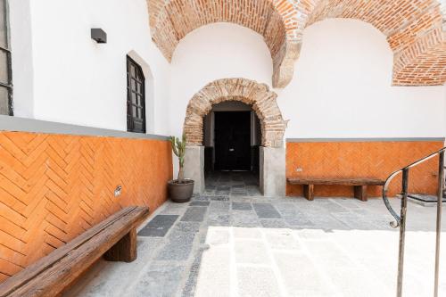 a hallway with two benches in a building at Casa 212 con WIFI alta velocidad y estacionamiento in Puebla