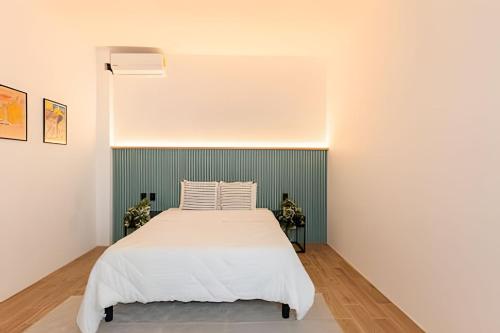 a bedroom with a white bed and a green wall at Casa 212 con WIFI alta velocidad y estacionamiento in Puebla