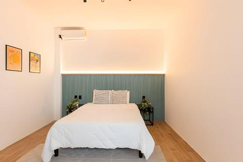 a bedroom with a white bed and a wall at Casa 212 con WIFI alta velocidad y estacionamiento in Puebla