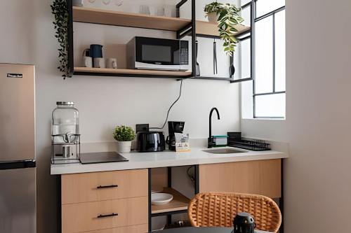 a kitchen with a counter with a microwave and a sink at Casa 212 con WIFI alta velocidad y estacionamiento in Puebla