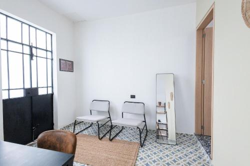 two chairs sitting in a room with a mirror at Casa 212 con WIFI alta velocidad y estacionamiento in Puebla