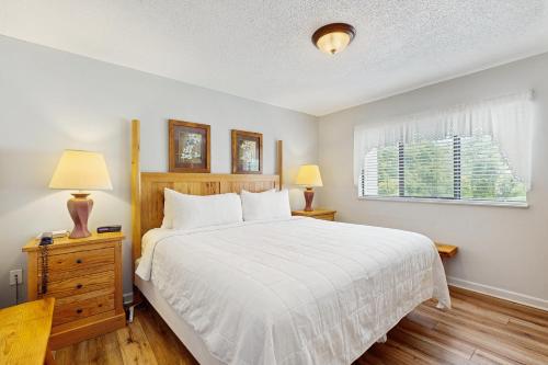 Un dormitorio con una cama y dos lámparas y una ventana. en Laurel Inn Condominiums - Gatlinburg Getaway, en Gatlinburg