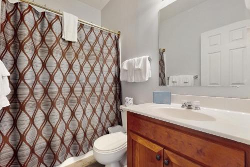 Un baño con lavabo, inodoro y ducha. en Laurel Inn Condominiums - Black Bear Boogie, en Gatlinburg