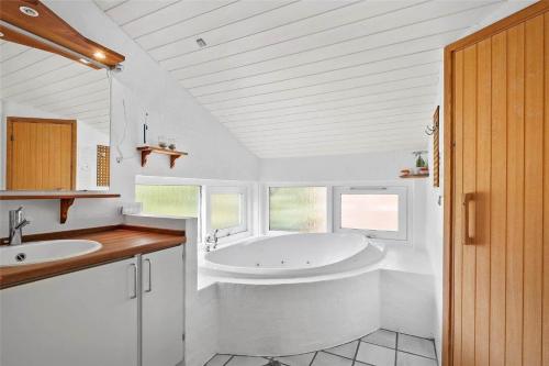 a white bathroom with a tub and a sink at OH285-Hadsund-Mollevaenget-19 in Hadsund