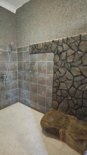a bathroom with a shower with a tree mural on the wall at Waghill Presidential Penthouse in Mwanza