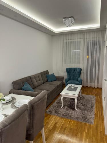 a living room with a couch and a table at Apartman Mojsilović in Ub