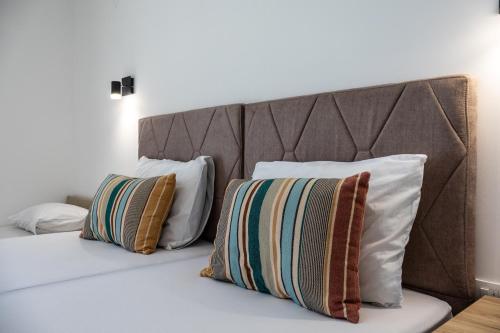 a bed with two pillows on top of it at Sienna Apartments Budva in Budva