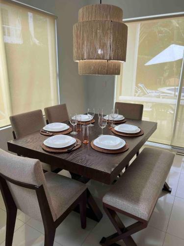 a wooden table with chairs and a dining room at La Casa del Mar, Club Santiago with a private pool in Manzanillo