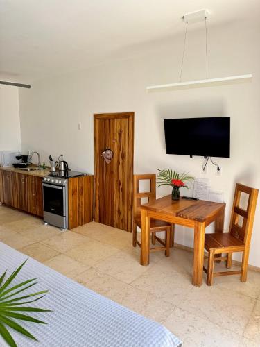 a living room with a wooden table and a television at Roatan Infinity Pool and Ocean View Apartment in Jonesville