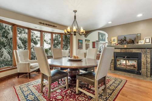 a dining room with a table and chairs and a fireplace at Luxury Home with Private Hot Tub, Woodburning Fireplace, Pet Friendly in Vail
