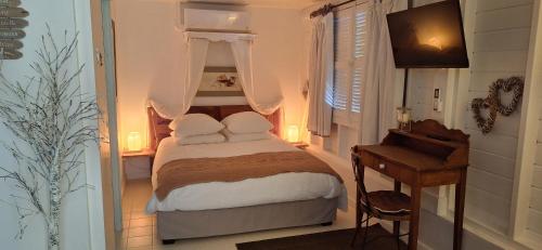 a small bedroom with a bed and a desk at Les Gîtes de Bergette in Petit-Bourg