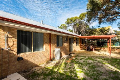 a brick house with a table and chairs in the yard at Waves And Moore - Beautifully presented home in Guilderton