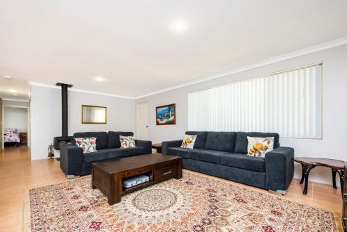 a living room with two couches and a coffee table at Waves And Moore - Beautifully presented home in Guilderton
