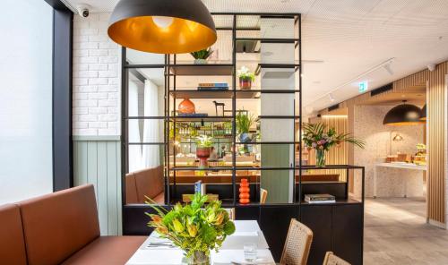 a dining room with a table and a yellow light fixture at Holiday Inn Melbourne Bourke Street Mall by IHG in Melbourne