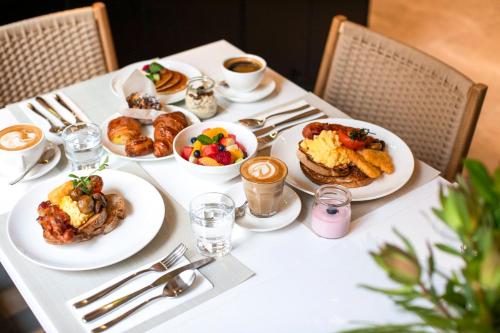 a table with plates of breakfast food on it at Holiday Inn Melbourne Bourke Street Mall by IHG in Melbourne