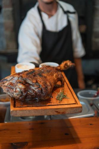 a chicken on a cutting board on a table at Correntoso Lake & River Hotel in Villa La Angostura