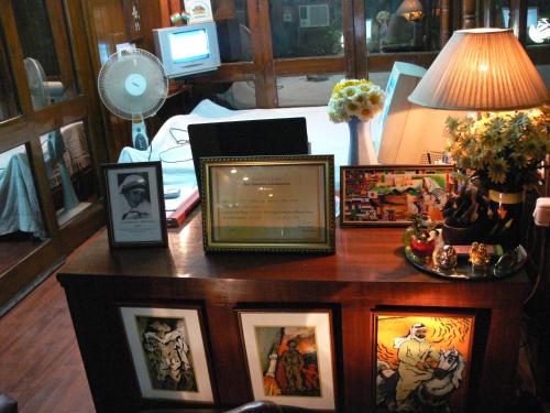 a table with framed pictures on it with a lamp at Petite Homestays in New Delhi