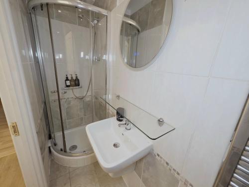 a white bathroom with a sink and a shower at Charming 2 bedrooms flat for 6 in King's Cross in London