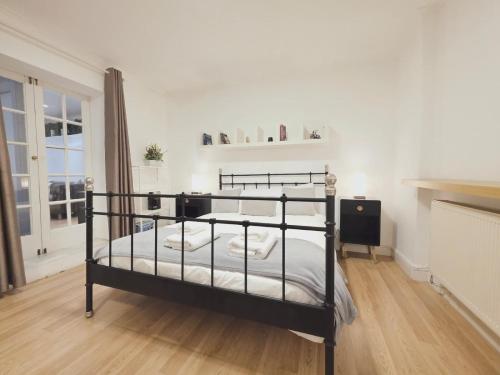 a bedroom with a black bunk bed with white sheets at Charming 2 bedrooms flat for 6 in King's Cross in London