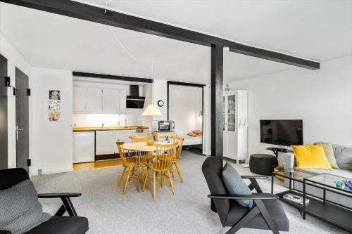 a living room with a table and chairs and a kitchen at 5514-Gudhjem-Holkavej-2-Lejl-3 in Gudhjem