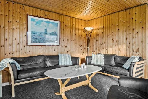 a living room with a leather couch and a table at LF14092-Roslev-Eskovvej-92 in Roslev
