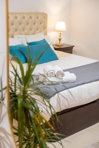a bedroom with a bed with towels and a plant at Villa Turquesa Estoril in Alcabideche