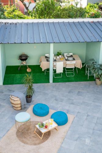 a patio with a blue roof with a table and chairs at Villa Turquesa Estoril in Alcabideche