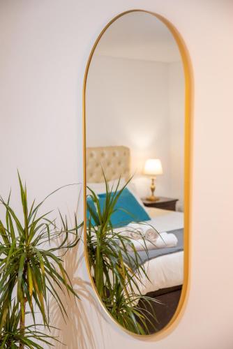 a mirror on a wall with a bed in a room at Villa Turquesa Estoril in Alcabideche