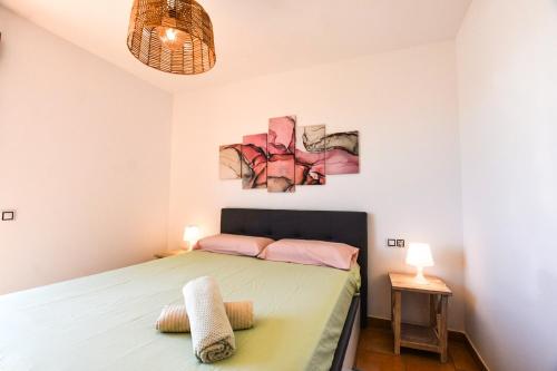 ein Schlafzimmer mit einem Bett und zwei Gemälden an der Wand in der Unterkunft Book Jet - Bella Vista VIP Villa in Majanicho