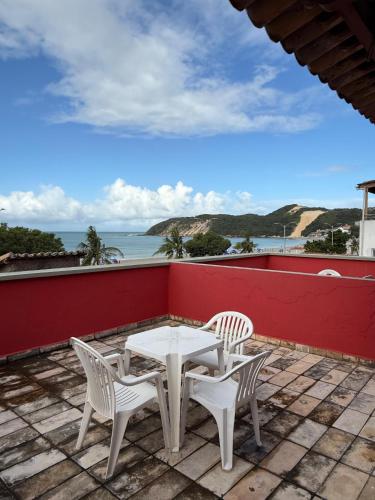 a patio with a table and chairs and the ocean at Ingá Praia hotel in Natal