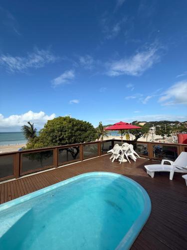 a swimming pool on a deck next to a beach at Ingá Praia hotel in Natal