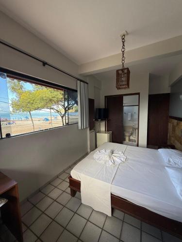 a bedroom with a large bed and a large window at Ingá Praia hotel in Natal