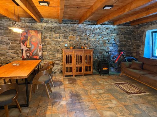 Una sala de estar con una mesa y una pared de piedra. en Ghebi Inn, en Oni