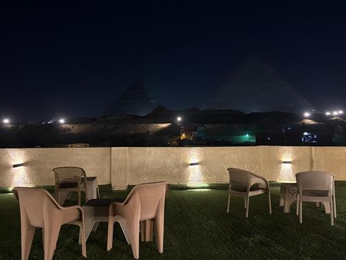 a group of chairs sitting on the grass at night at Alaska Pyramids Hotel in Cairo