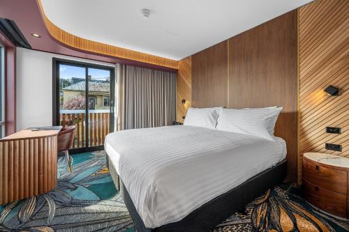 a hotel room with a bed and a balcony at George Hotel Launceston in Launceston