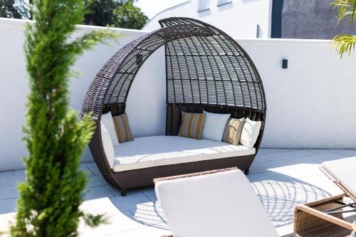 a rattan swing on a patio with a chair at Villa Ring Pool & Padel Belgrade in Barič