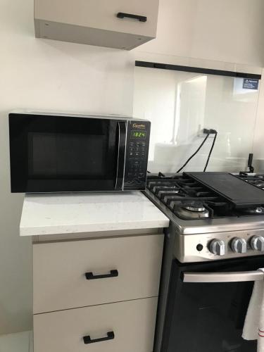 a microwave sitting on top of a stove in a kitchen at Phoenix Villa in Portmore