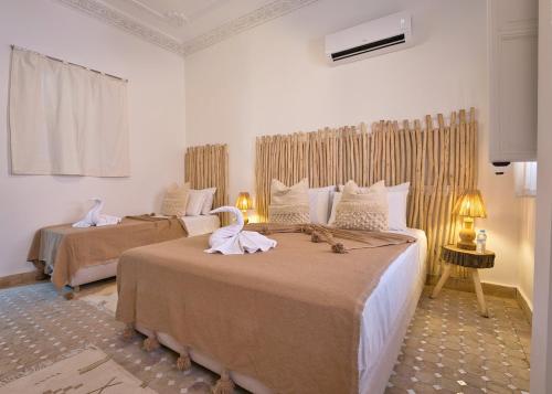 Un dormitorio con dos camas con toallas encima. en Dar Farah Riad luxe privé, 3ch, piscine chauffée, ptit déj, en Marrakech