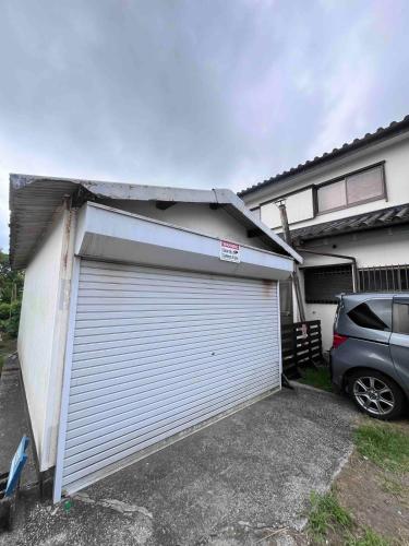a garage with a car parked in front of a house at Vacation rental PIGGY's Nichinan in Nichinan