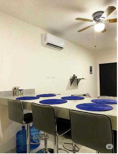 a room with a table with chairs and a ceiling fan at Departamento El Tesoro - Olas Azules - 3 Min Malecón y Playas in Mazatlán