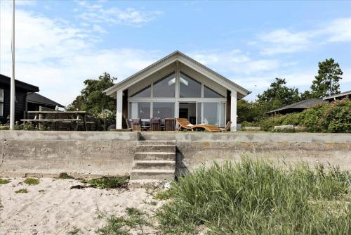 a small house on the beach with a porch at FY304-Svendborg-Smormosevaenget-17 in Svendborg