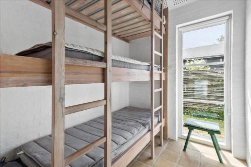 a bunk bed room with two bunk beds and a window at FY304-Svendborg-Smormosevaenget-17 in Svendborg