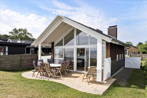 a house with a patio with a table and chairs at FY304-Svendborg-Smormosevaenget-17 in Svendborg