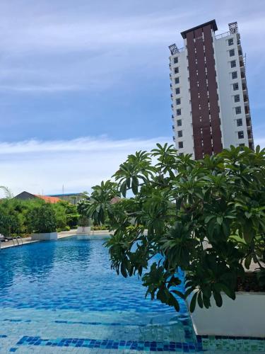 a view of a swimming pool with a tall building at EuroAsian Royal Oceancrest Mactan in Sudtungan